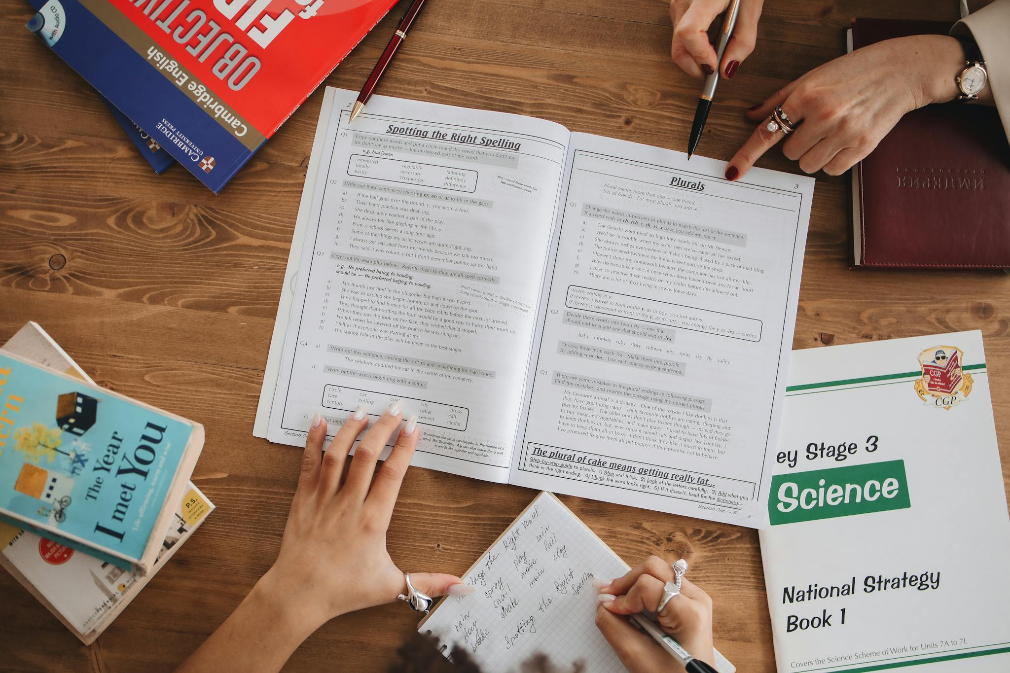 Overhead view of students studying with open books and taking notes, highlighting education and learning.